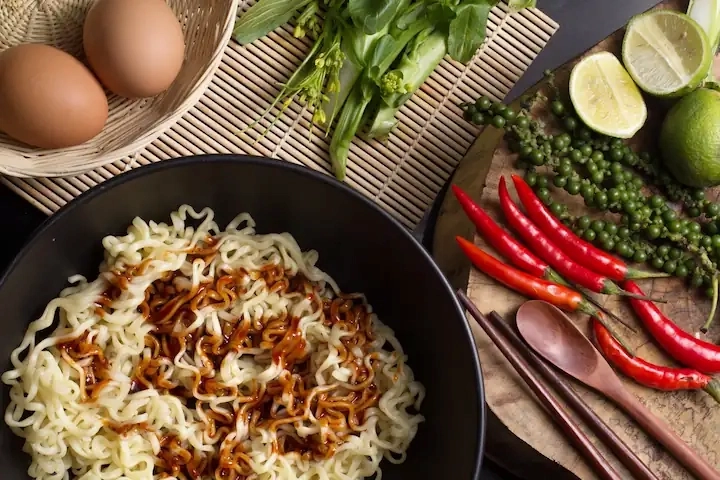 Flatlay image of noodles, eggs, and other vegtables beside